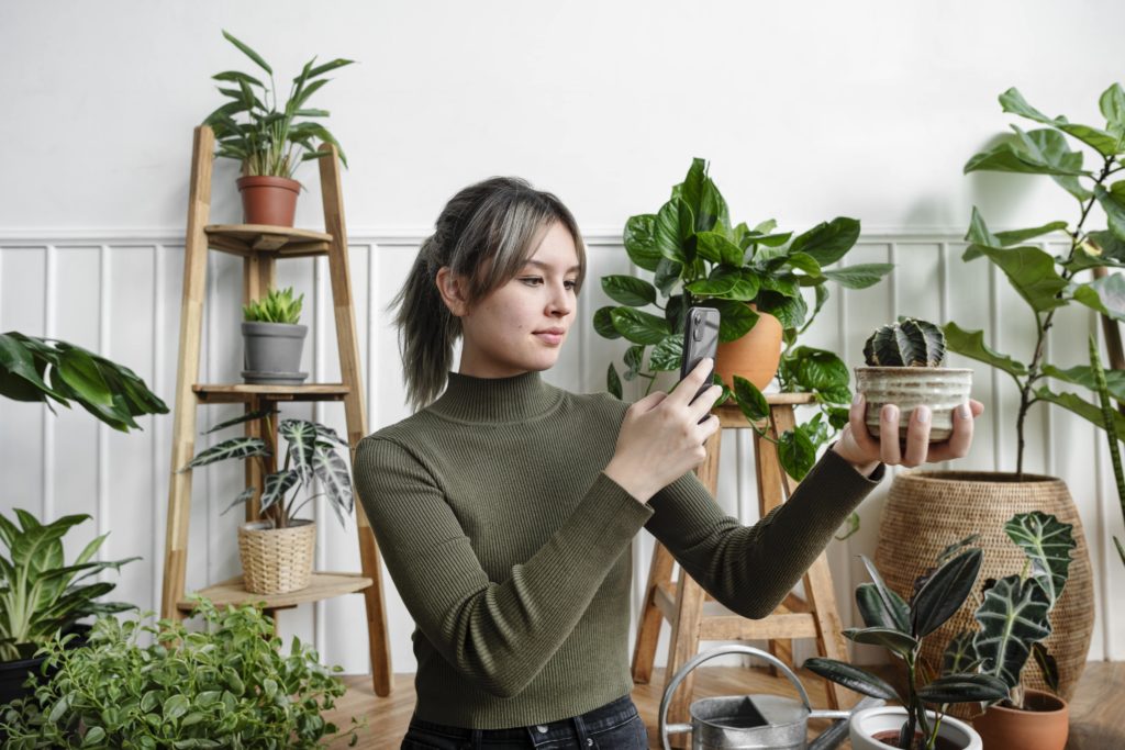 woman taking photo of plant to promote her business on social media